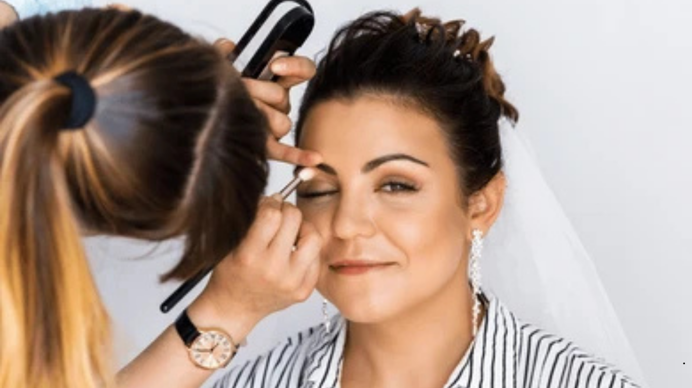 Bridal makeup artist enhancing bride’s natural beauty